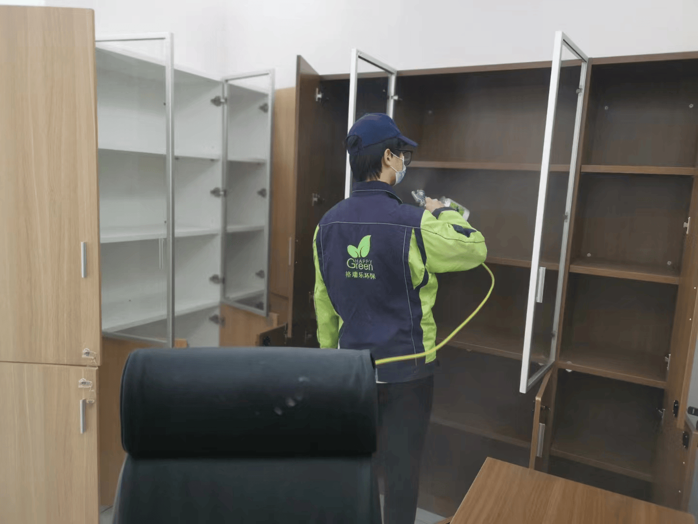 阁楼里,施工人员在狭窄空间内相互协作,一人在有限的空间中操作工具对家具进行除醛处理,另一人在旁边提供照明和协助传递材料,共同完成家具的除醛工作,两人在狭小的空间里默契配合。